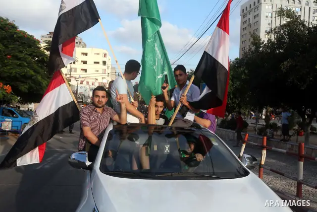 Palestinians hold national and Egyptian flags as they celebrate in Gaza City, the victory of Muslim Brotherhood's presidential candidate, Mohamed Morsi, in the Egyptian elections on June 24, 2012. Arab governments and le...