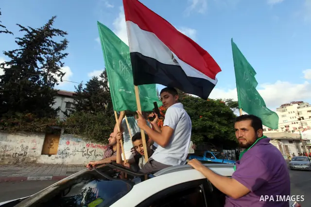 Palestinians hold national and Egyptian flags as they celebrate in Gaza City, the victory of Muslim Brotherhood's presidential candidate, Mohamed Morsi, in the Egyptian elections on June 24, 2012. Arab governments and le...