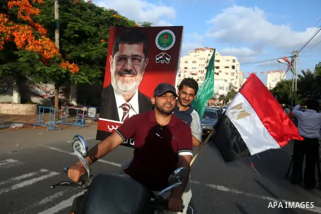 Palestinians hold national and Egyptian flags as they celebrate in Gaza City, the victory of Muslim Brotherhood's presidential candidate, Mohamed Morsi, in the Egyptian elections on June 24, 2012. Arab governments and le...