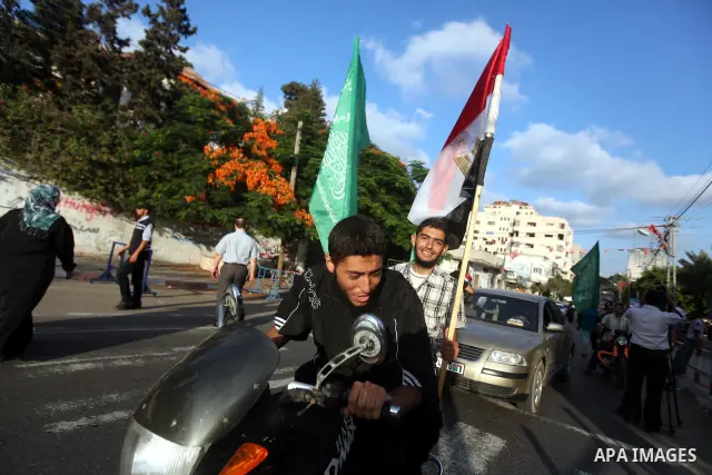 Palestinians hold national and Egyptian flags as they celebrate in Gaza City, the victory of Muslim Brotherhood's presidential candidate, Mohamed Morsi, in the Egyptian elections on June 24, 2012. Arab governments and le...