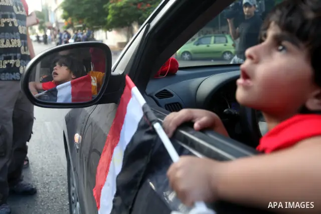 Palestinians hold national and Egyptian flags as they celebrate in Gaza City, the victory of Muslim Brotherhood's presidential candidate, Mohamed Morsi, in the Egyptian elections on June 24, 2012. Arab governments and le...
