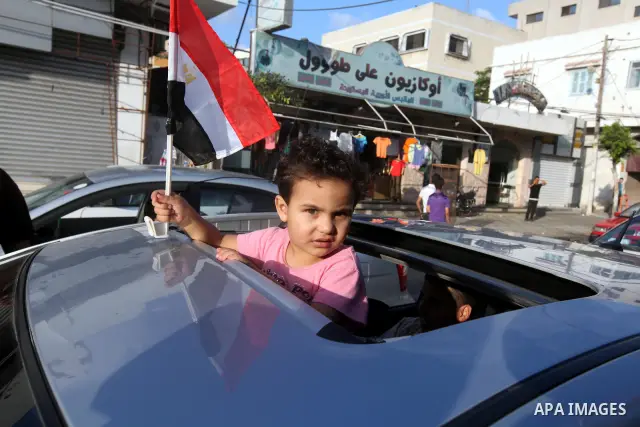 Palestinians hold national and Egyptian flags as they celebrate in Gaza City, the victory of Muslim Brotherhood's presidential candidate, Mohamed Morsi, in the Egyptian elections on June 24, 2012. Arab governments and le...