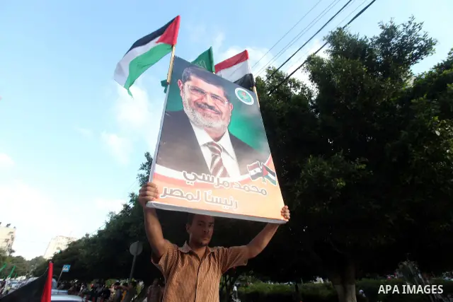 Palestinians hold national and Egyptian flags as they celebrate in Gaza City, the victory of Muslim Brotherhood's presidential candidate, Mohamed Morsi, in the Egyptian elections on June 24, 2012. Arab governments and le...