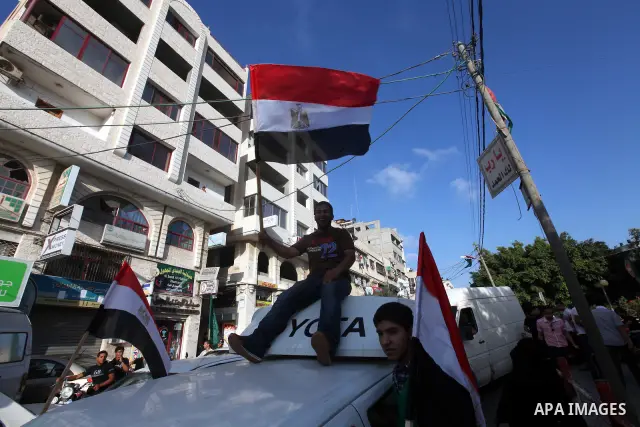 Palestinians hold national and Egyptian flags as they celebrate in Gaza City, the victory of Muslim Brotherhood's presidential candidate, Mohamed Morsi, in the Egyptian elections on June 24, 2012. Arab governments and le...