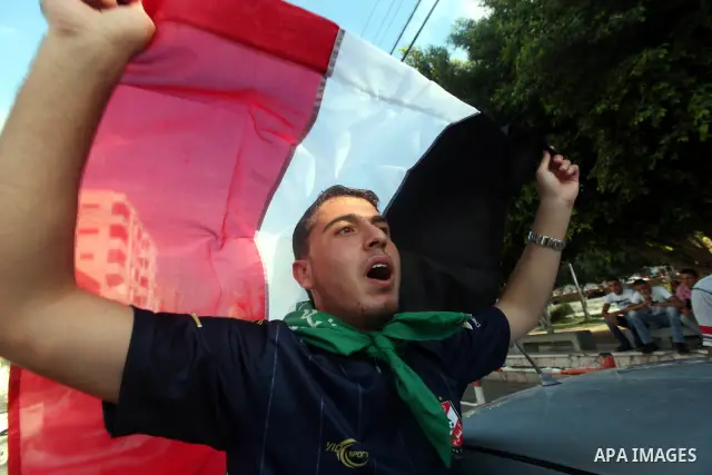 Palestinians hold national and Egyptian flags as they celebrate in Gaza City, the victory of Muslim Brotherhood's presidential candidate, Mohamed Morsi, in the Egyptian elections on June 24, 2012. Arab governments and le...