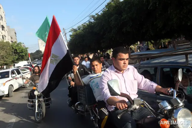 Palestinians hold national and Egyptian flags as they celebrate in Gaza City, the victory of Muslim Brotherhood's presidential candidate, Mohamed Morsi, in the Egyptian elections on June 24, 2012. Arab governments and le...