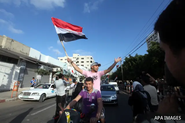 Palestinians hold national and Egyptian flags as they celebrate in Gaza City, the victory of Muslim Brotherhood's presidential candidate, Mohamed Morsi, in the Egyptian elections on June 24, 2012. Arab governments and le...