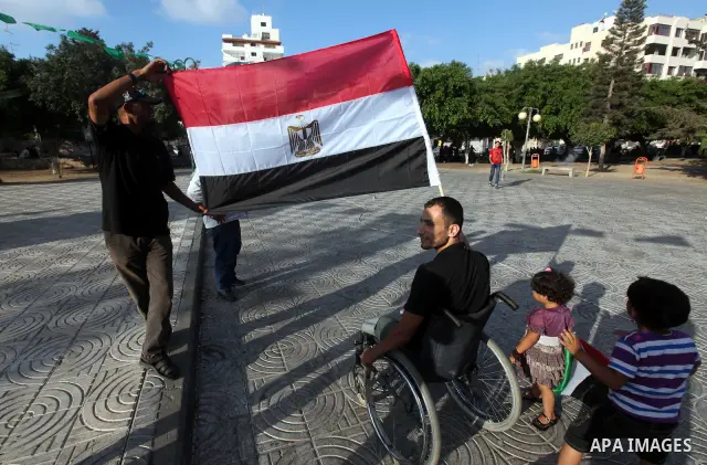 Palestinians hold national and Egyptian flags as they celebrate in Gaza City, the victory of Muslim Brotherhood's presidential candidate, Mohamed Morsi, in the Egyptian elections on June 24, 2012. Arab governments and le...