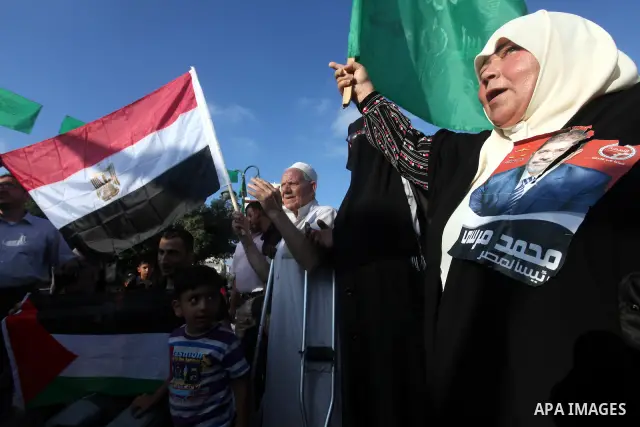 Palestinians hold national and Egyptian flags as they celebrate in Gaza City, the victory of Muslim Brotherhood's presidential candidate, Mohamed Morsi, in the Egyptian elections on June 24, 2012. Arab governments and le...