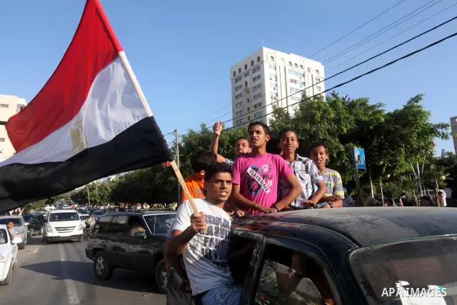 Palestinians hold national and Egyptian flags as they celebrate in Gaza City, the victory of Muslim Brotherhood's presidential candidate, Mohamed Morsi, in the Egyptian elections on June 24, 2012. Arab governments and le...
