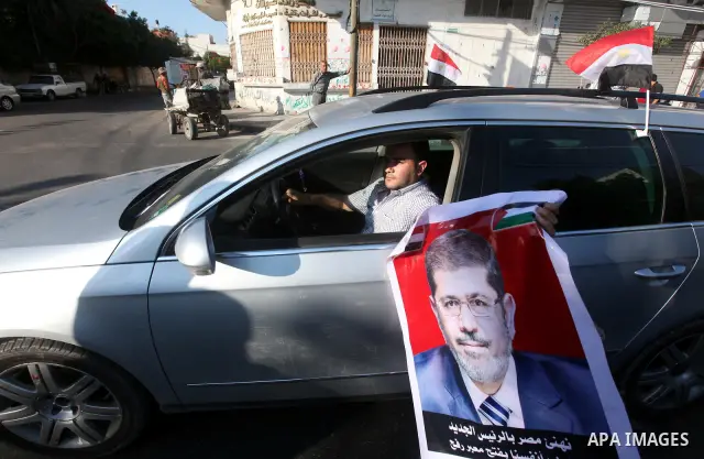 Palestinians hold national and Egyptian flags as they celebrate in Gaza City, the victory of Muslim Brotherhood's presidential candidate, Mohamed Morsi, in the Egyptian elections on June 24, 2012. Arab governments and le...