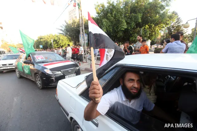 Palestinians hold national and Egyptian flags as they celebrate in Gaza City, the victory of Muslim Brotherhood's presidential candidate, Mohamed Morsi, in the Egyptian elections on June 24, 2012. Arab governments and le...