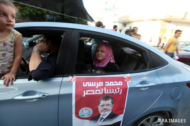 Palestinians hold national and Egyptian flags as they celebrate in Gaza City, the victory of Muslim Brotherhood's presidential candidate, Mohamed Morsi, in the Egyptian elections on June 24, 2012. Arab governments and le...