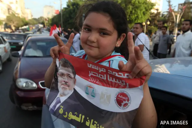 Palestinians hold national and Egyptian flags as they celebrate in Gaza City, the victory of Muslim Brotherhood's presidential candidate, Mohamed Morsi, in the Egyptian elections on June 24, 2012. Arab governments and le...