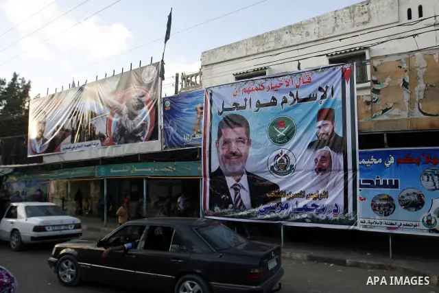 Palestinians hold national and Egyptian flags as they celebrate in Rafah town, in the southern Gaza Strip, the victory of the Muslim Brotherhood's presidential candidate, Mohamed Morsi in the Egyptian presidential electi...