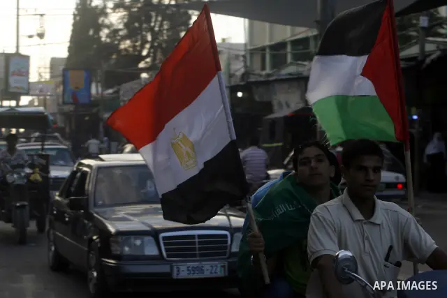 Palestinians hold national and Egyptian flags as they celebrate in Rafah town, in the southern Gaza Strip, the victory of the Muslim Brotherhood's presidential candidate, Mohamed Morsi in the Egyptian presidential electi...