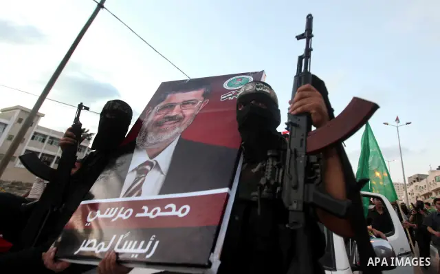 Hamas militants hold a poster depicting Mohamed Morsy of the Muslim Brotherhood after the Egyptian Presidential election committee announced him as victor. The Muslim Brotherhood's Mohammed Morsi became Egypt's first fre...