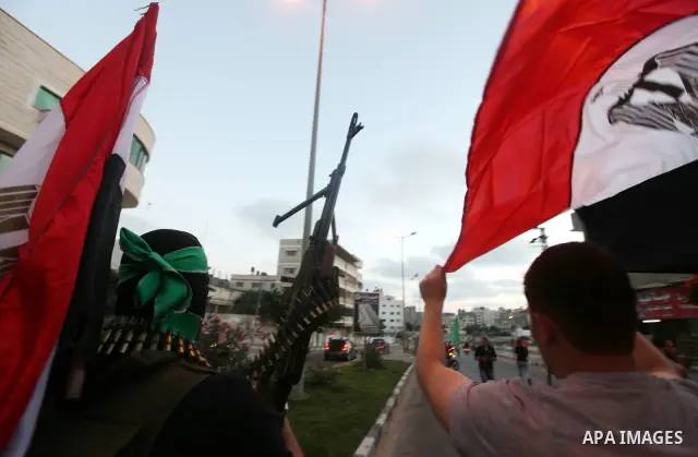 Hamas militants hold a poster depicting Mohamed Morsy of the Muslim Brotherhood as they celebrate in the street in Gaza City after he was declared Egypt's first democratic president June 24, 2012. Morsy's win was hailed...