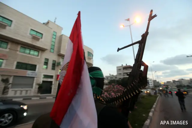 Hamas militants hold a poster depicting Mohamed Morsy of the Muslim Brotherhood as they celebrate in the street in Gaza City after he was declared Egypt's first democratic president June 24, 2012. Morsy's win was hailed...