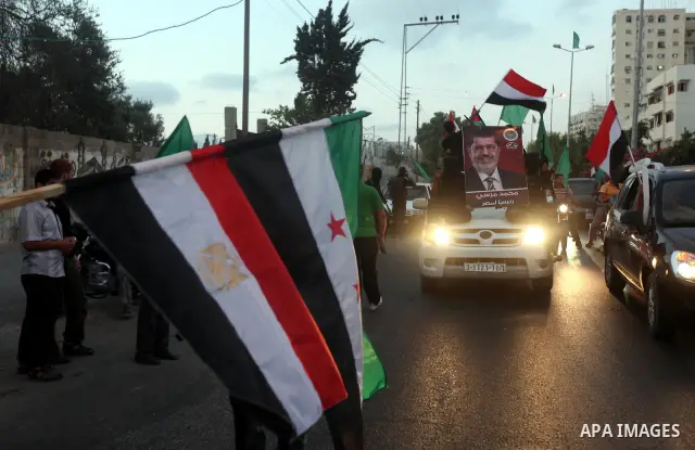 Hamas militants hold a poster depicting Mohamed Morsy of the Muslim Brotherhood after the Egyptian Presidential election committee announced him as victor. The Muslim Brotherhood's Mohammed Morsi became Egypt's first fre...