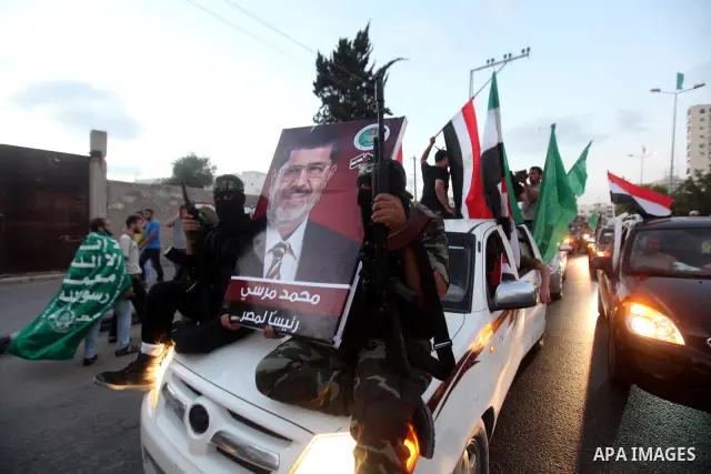 Hamas militants hold a poster depicting Mohamed Morsy of the Muslim Brotherhood after the Egyptian Presidential election committee announced him as victor. The Muslim Brotherhood's Mohammed Morsi became Egypt's first fre...