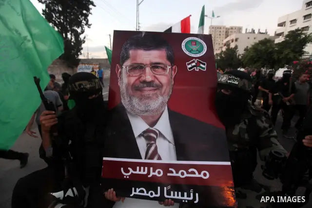 Hamas militants hold a poster depicting Mohamed Morsy of the Muslim Brotherhood after the Egyptian Presidential election committee announced him as victor. The Muslim Brotherhood's Mohammed Morsi became Egypt's first fre...