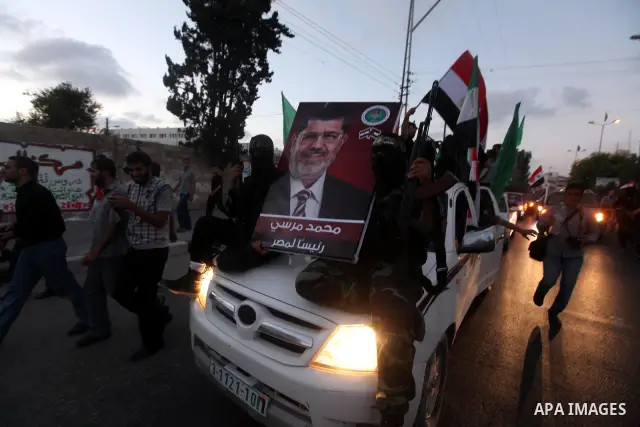 Hamas militants hold a poster depicting Mohamed Morsy of the Muslim Brotherhood after the Egyptian Presidential election committee announced him as victor. The Muslim Brotherhood's Mohammed Morsi became Egypt's first fre...