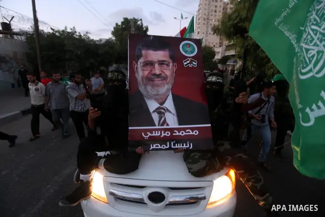 Hamas militants hold a poster depicting Mohamed Morsy of the Muslim Brotherhood after the Egyptian Presidential election committee announced him as victor. The Muslim Brotherhood's Mohammed Morsi became Egypt's first fre...