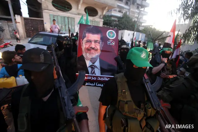 Hamas militants hold a poster depicting Mohamed Morsy of the Muslim Brotherhood after the Egyptian Presidential election committee announced him as victor. The Muslim Brotherhood's Mohammed Morsi became Egypt's first fre...