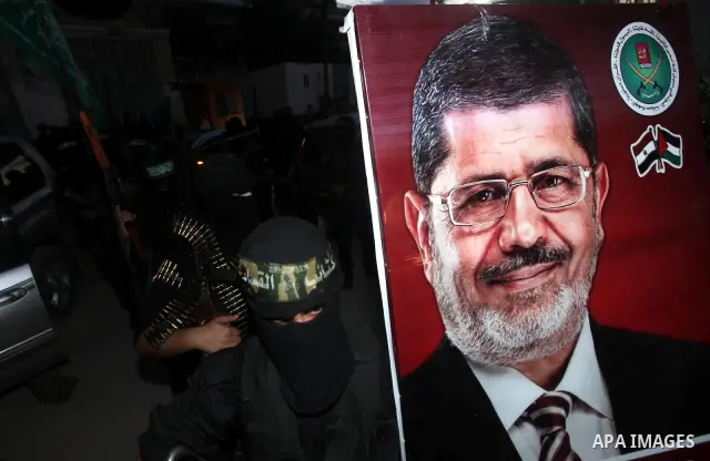 Hamas militants hold a poster depicting Mohamed Morsy of the Muslim Brotherhood after the Egyptian Presidential election committee announced him as victor. The Muslim Brotherhood's Mohammed Morsi became Egypt's first fre...