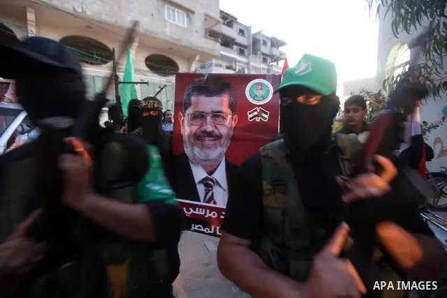 Hamas militants hold a poster depicting Mohamed Morsy of the Muslim Brotherhood after the Egyptian Presidential election committee announced him as victor. The Muslim Brotherhood's Mohammed Morsi became Egypt's first fre...