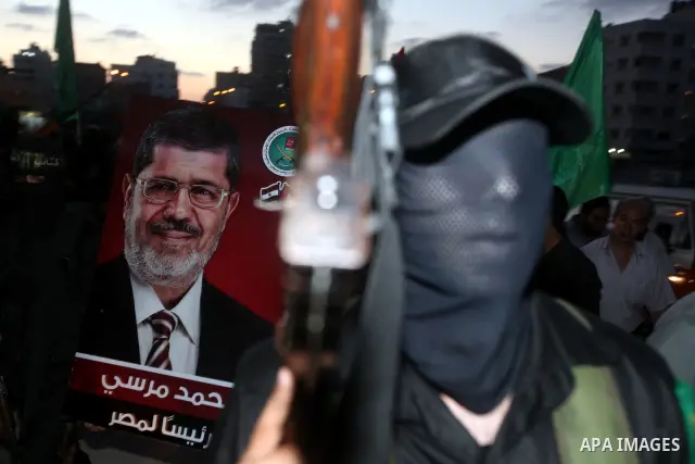 Hamas militants hold a poster depicting Mohamed Morsy of the Muslim Brotherhood after the Egyptian Presidential election committee announced him as victor. The Muslim Brotherhood's Mohammed Morsi became Egypt's first fre...