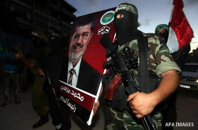 Hamas militants hold a poster depicting Mohamed Morsy of the Muslim Brotherhood after the Egyptian Presidential election committee announced him as victor. The Muslim Brotherhood's Mohammed Morsi became Egypt's first fre...