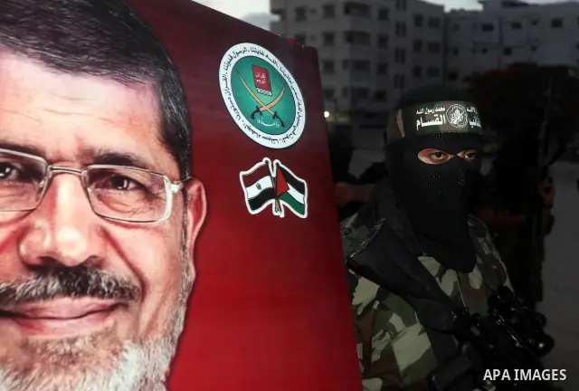 Hamas militants hold a poster depicting Mohamed Morsy of the Muslim Brotherhood after the Egyptian Presidential election committee announced him as victor. The Muslim Brotherhood's Mohammed Morsi became Egypt's first fre...