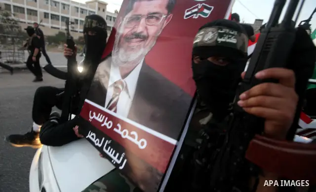 Hamas militants hold a poster depicting Mohamed Morsy of the Muslim Brotherhood after the Egyptian Presidential election committee announced him as victor. The Muslim Brotherhood's Mohammed Morsi became Egypt's first fre...