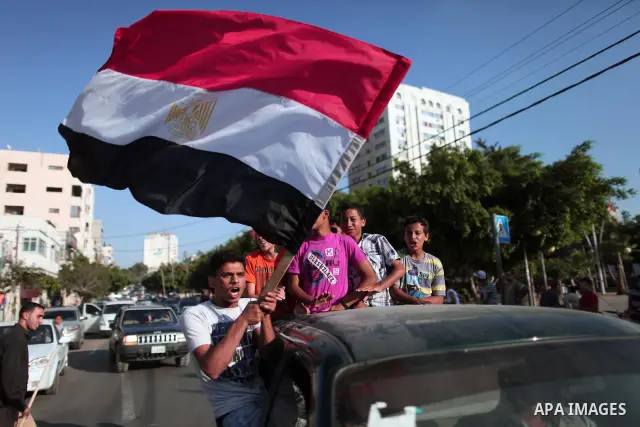 A Palestinian youth waves the Egyptian flag as he celebrate, in Gaza Strip, the victory of the Muslim Brotherhood's presidential candidate, Mohamed Morsi in the Egyptian presidential elections on June 24, 2012. Arab gove...