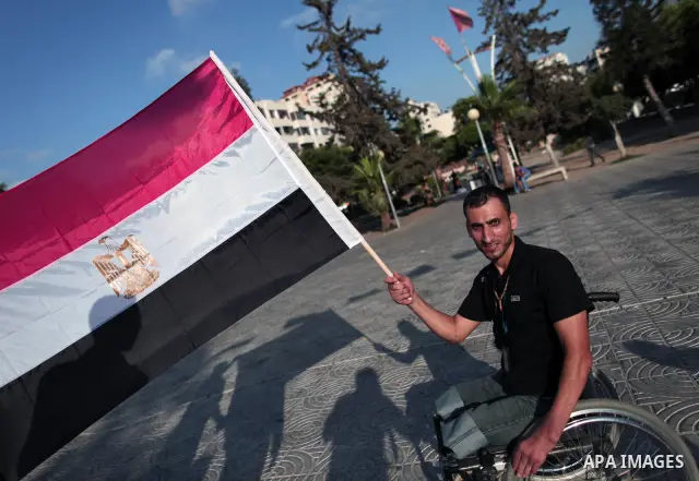 A Palestinian youth waves the Egyptian flag as he celebrate, in Gaza Strip, the victory of the Muslim Brotherhood's presidential candidate, Mohamed Morsi in the Egyptian presidential elections on June 24, 2012. Arab gove...