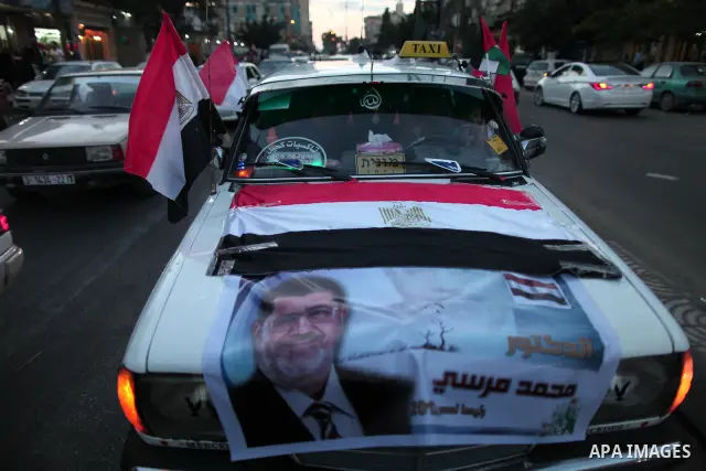 Palestinians hold national and Egyptian flags as they celebrate in Gaza City, the victory of Muslim Brotherhood's presidential candidate, Mohamed Morsi, in the Egyptian elections on June 24, 2012. Arab governments and le...