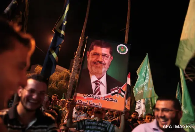 Palestinians hold national and Egyptian flags as they celebrate in Gaza City, the victory of Muslim Brotherhood's presidential candidate, Mohamed Morsi, in the Egyptian elections on June 24, 2012. Arab governments and le...