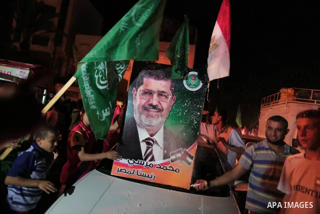 Palestinians hold national and Egyptian flags as they celebrate in Gaza City, the victory of Muslim Brotherhood's presidential candidate, Mohamed Morsi, in the Egyptian elections on June 24, 2012. Arab governments and le...