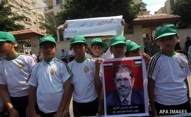 Palestinian boys supporter hold up images for Mohamed Morsi's and palestinian prisoners during celebrations after Muslim Brotherhood's presidential candidate Mohamed Morsi's victory in the Egyptian elections. Palestinian...