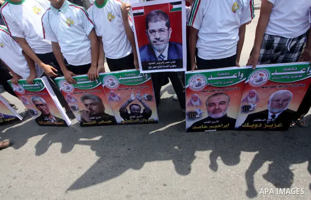 Palestinian boys supporter hold up images for Mohamed Morsi's and palestinian prisoners during celebrations after Muslim Brotherhood's presidential candidate Mohamed Morsi's victory in the Egyptian elections. Palestinian...