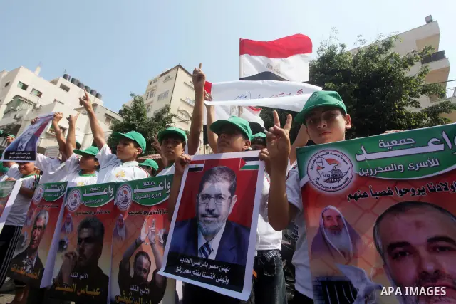 Palestinian boys supporter hold up images for Mohamed Morsi's and palestinian prisoners during celebrations after Muslim Brotherhood's presidential candidate Mohamed Morsi's victory in the Egyptian elections. Palestinian...