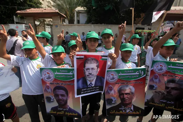 Palestinian boys supporter hold up images for Mohamed Morsi's and palestinian prisoners during celebrations after Muslim Brotherhood's presidential candidate Mohamed Morsi's victory in the Egyptian elections. Palestinian...