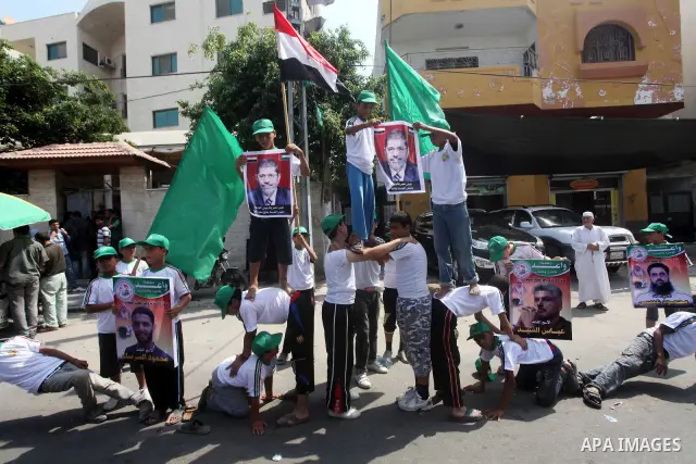 Palestinian boys supporter hold flags of Egypt and Hamas during celebrations after Muslim Brotherhood's presidential candidate Mohamed Morsi's victory in the Egyptian elections, Palestinians gather during a protest in fr...