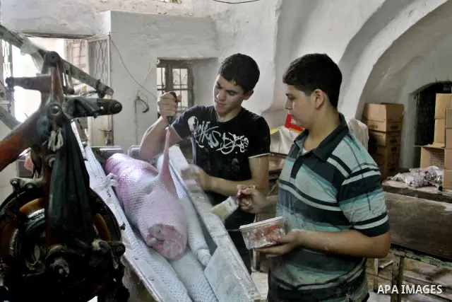 Palestinian labourers work at a factory for making a kind of candy " Toffee" in the West Bank city of Nablus on July 26, 2012. Photo by Nedal Eshtayah