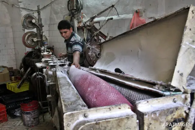 Palestinian labourers work at a factory for making a kind of candy " Toffee" in the West Bank city of Nablus on July 26, 2012. Photo by Nedal Eshtayah