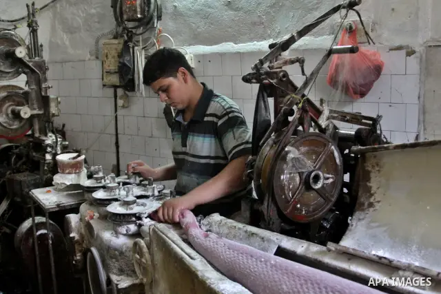 Palestinian labourers work at a factory for making a kind of candy " Toffee" in the West Bank city of Nablus on July 26, 2012. Photo by Nedal Eshtayah
