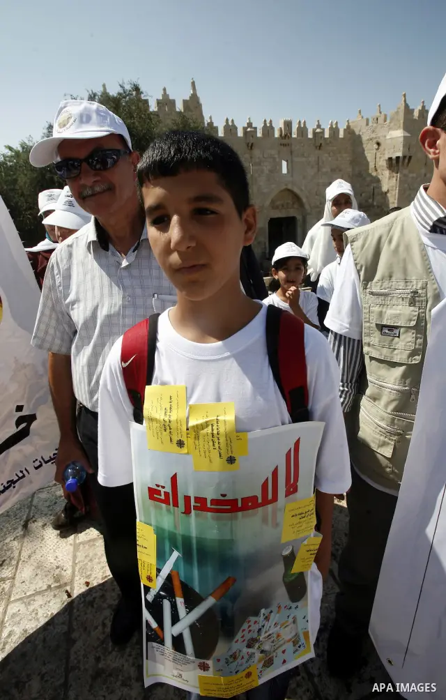 A Palestinian child holds banner with slogans against drug during a rally as part of events of an International Day Against Drug in Jerusalem's Old City on June 26, 2012. Photo by Mahfouz Abu Turk