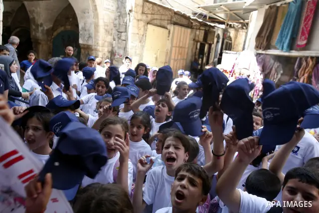 Palestinians children hold hats with the slogans against drug during a rally as part of events of an International Day Against Drug in Jerusalem's Old City on June 26, 2012. Photo by Mahfouz Abu Turk